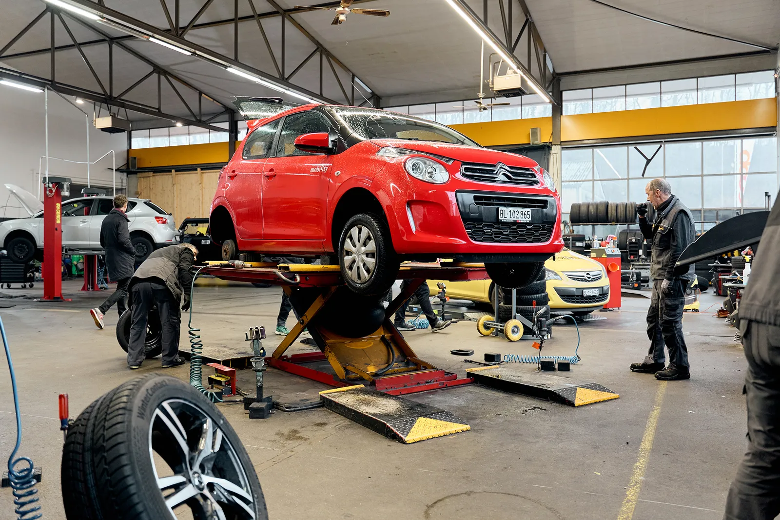 Mechaniker montiert Reifen an Mobility-Auto.