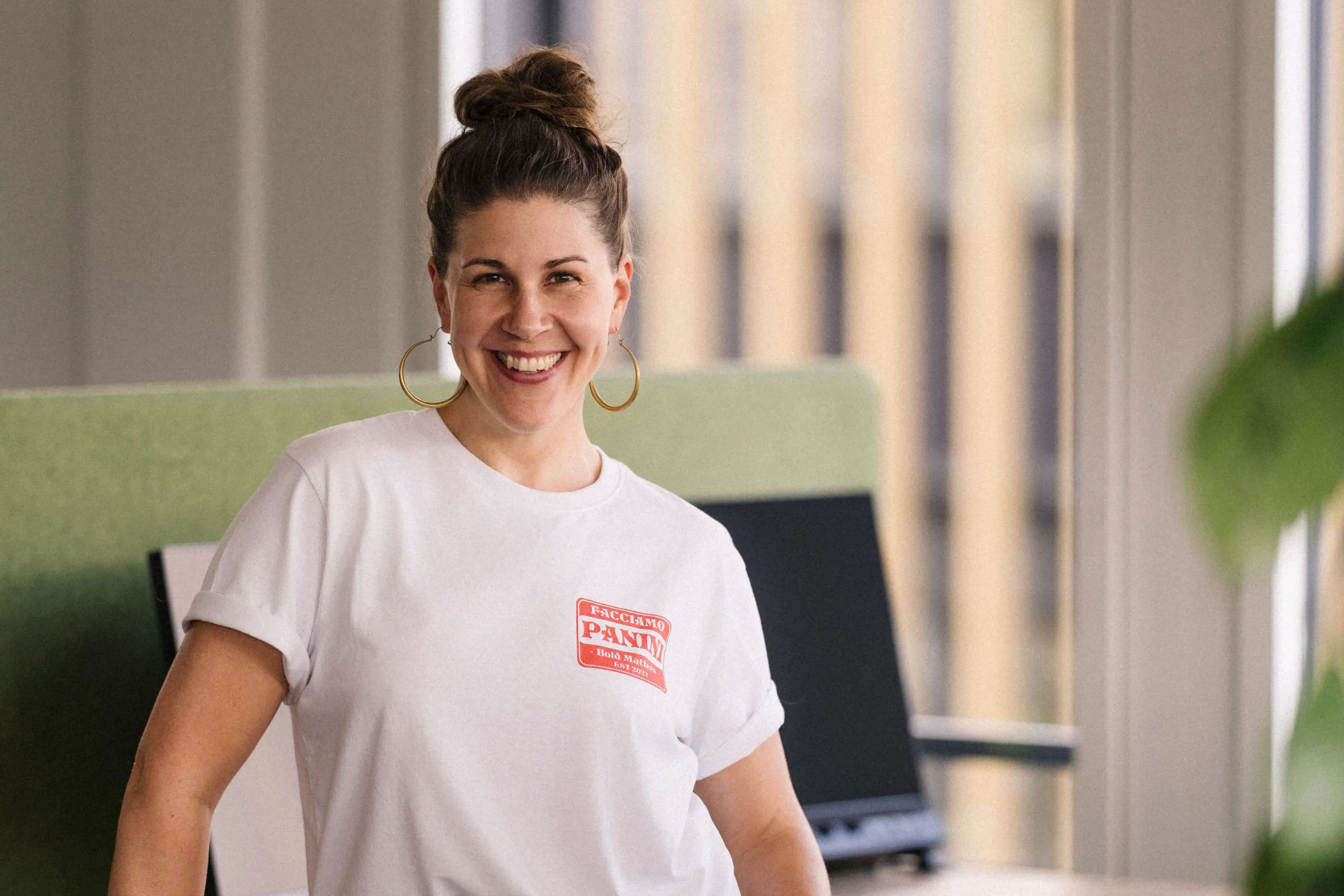 Noëlle Fischer lächelt in modernem Büro und blickt freundlich in die Kamera.